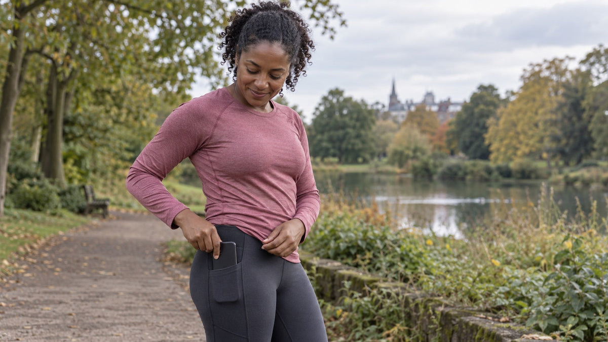 Runner placing her phone in the side pocket of her running leggings.