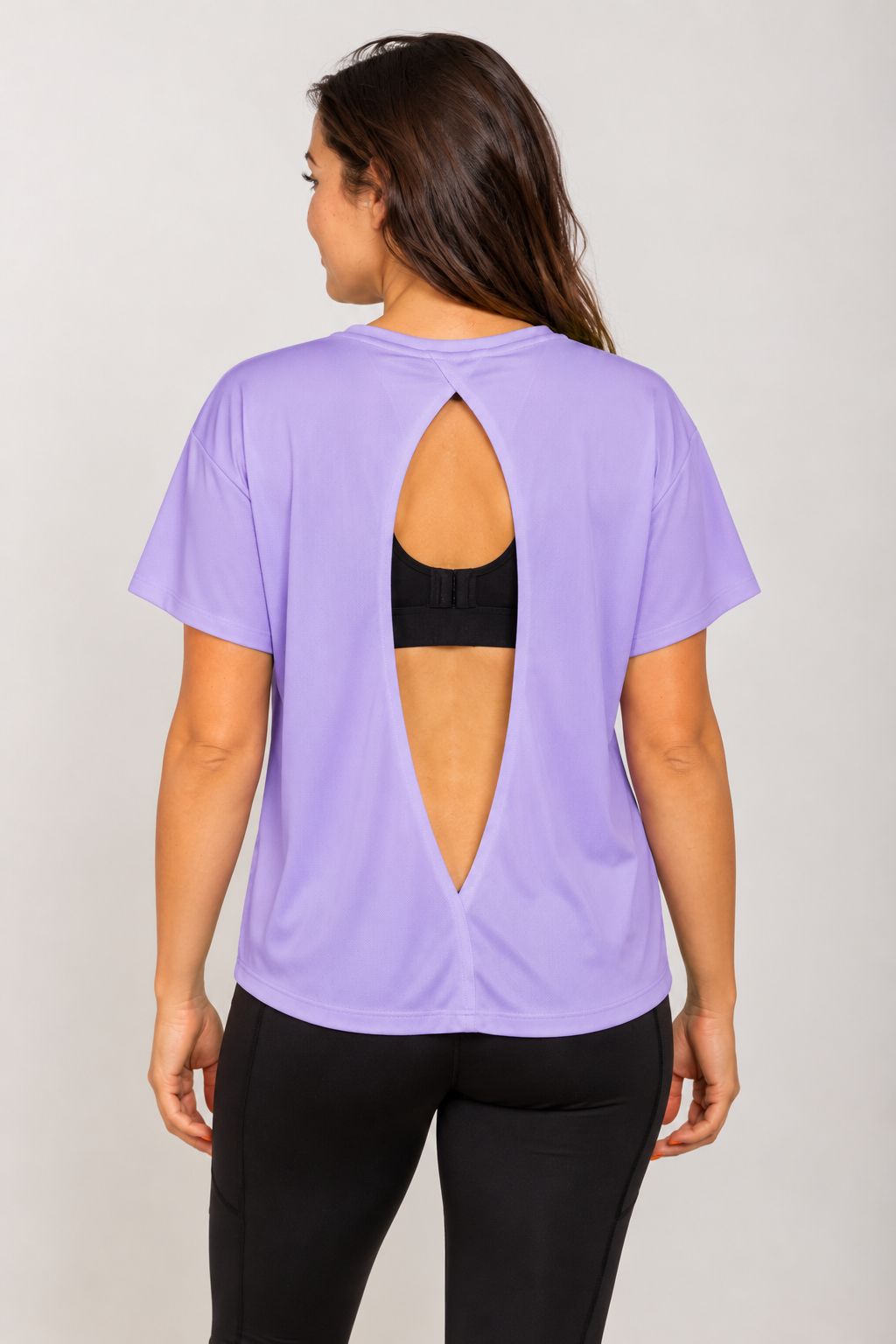 Lavender open-back Running Woman T-shirt on a brunette model viewed from behind with a black running bra visible through the open back