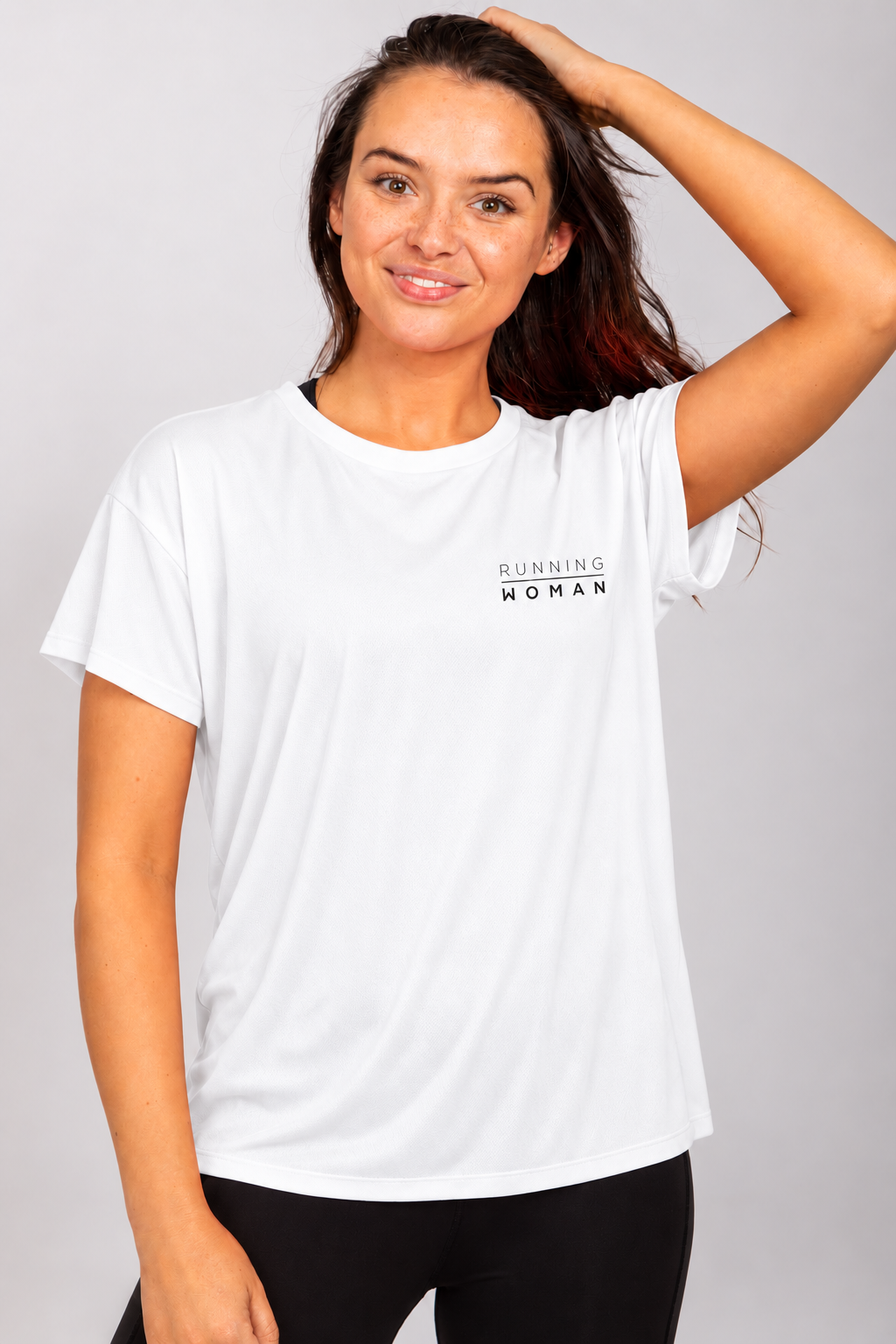 White open-back Running Woman T-shirt on a brunette model with one arm raised and her hand on her head