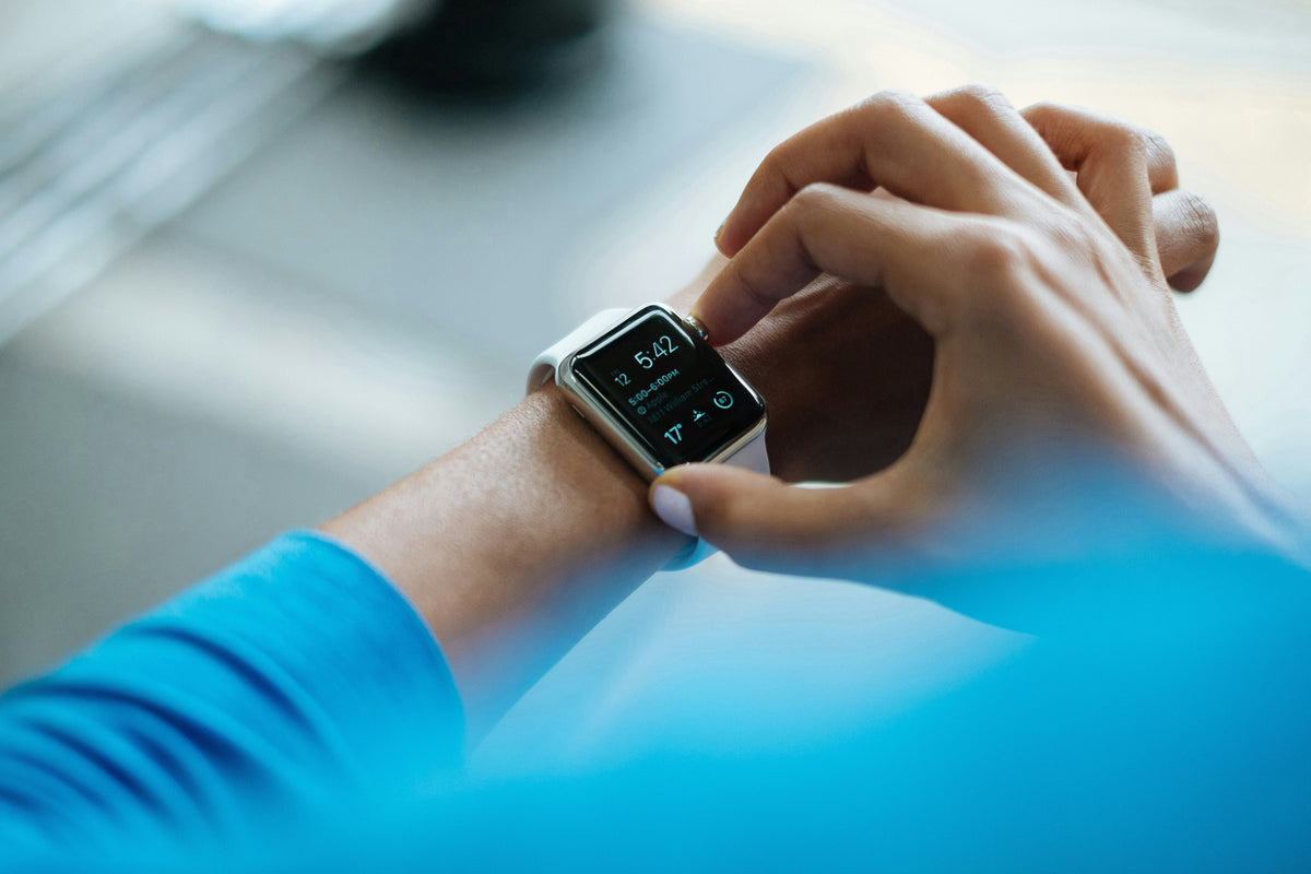 A person using the touchscreen of a smartwatch on their wrist.