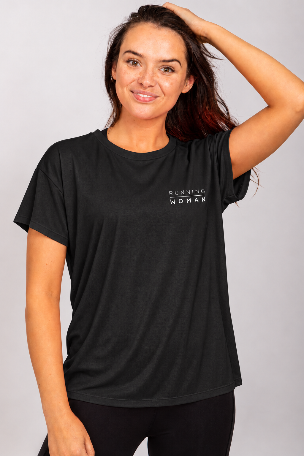 Black open-back Running Woman T-shirt on a brunette model with one arm raised and her hand on her head