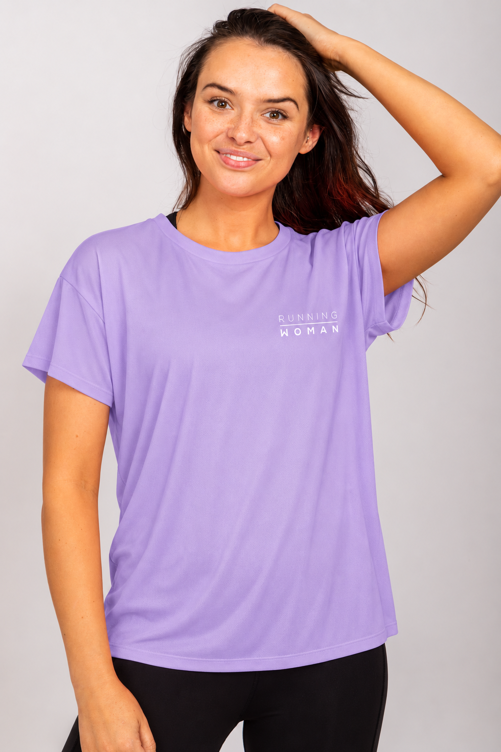 Lavender open-back Running Woman T-shirt on a brunette model with one arm raised and her hand on her head