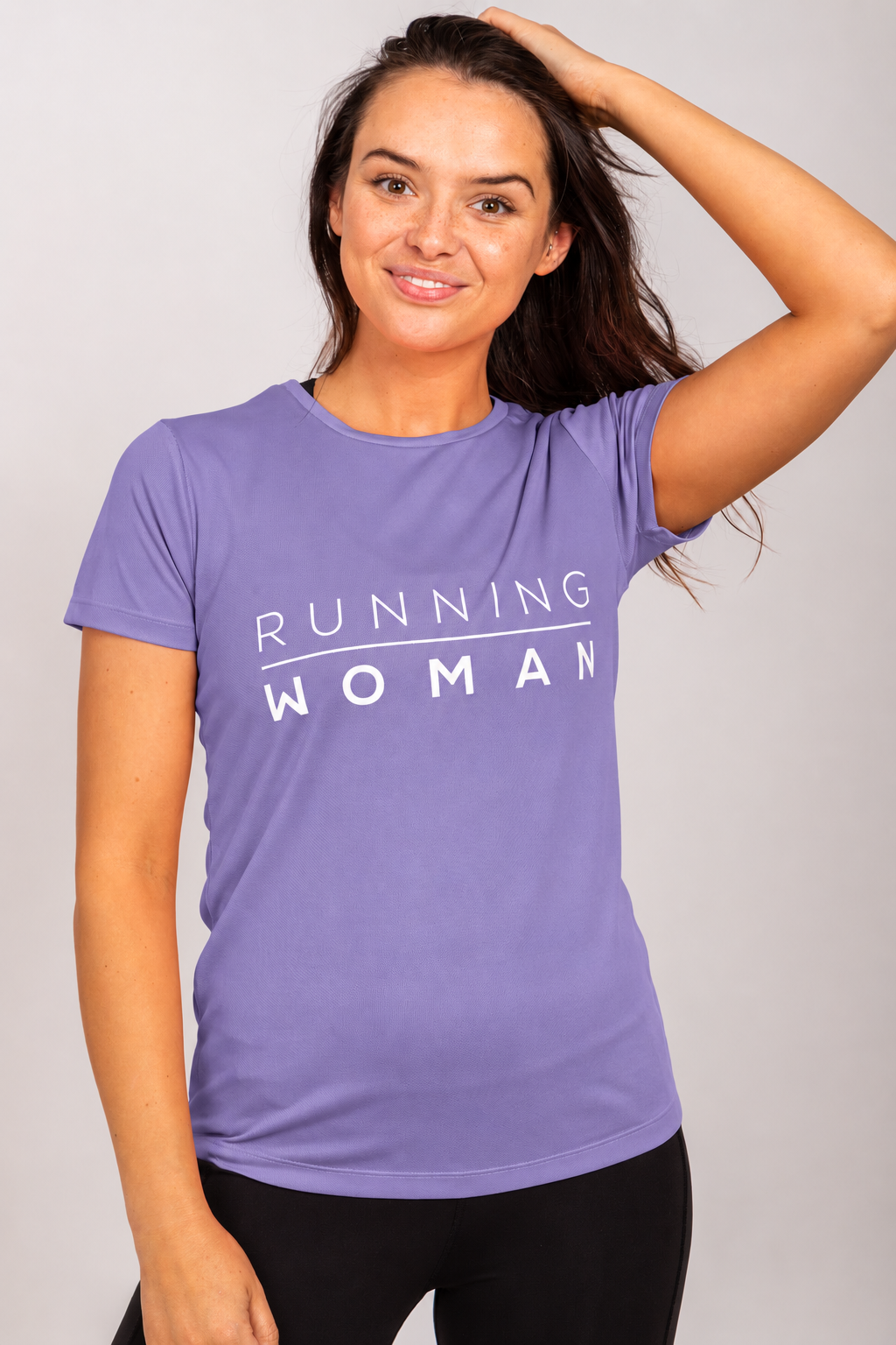 Model wearing the lavender Running Woman running T-shirt with one hand resting on her head