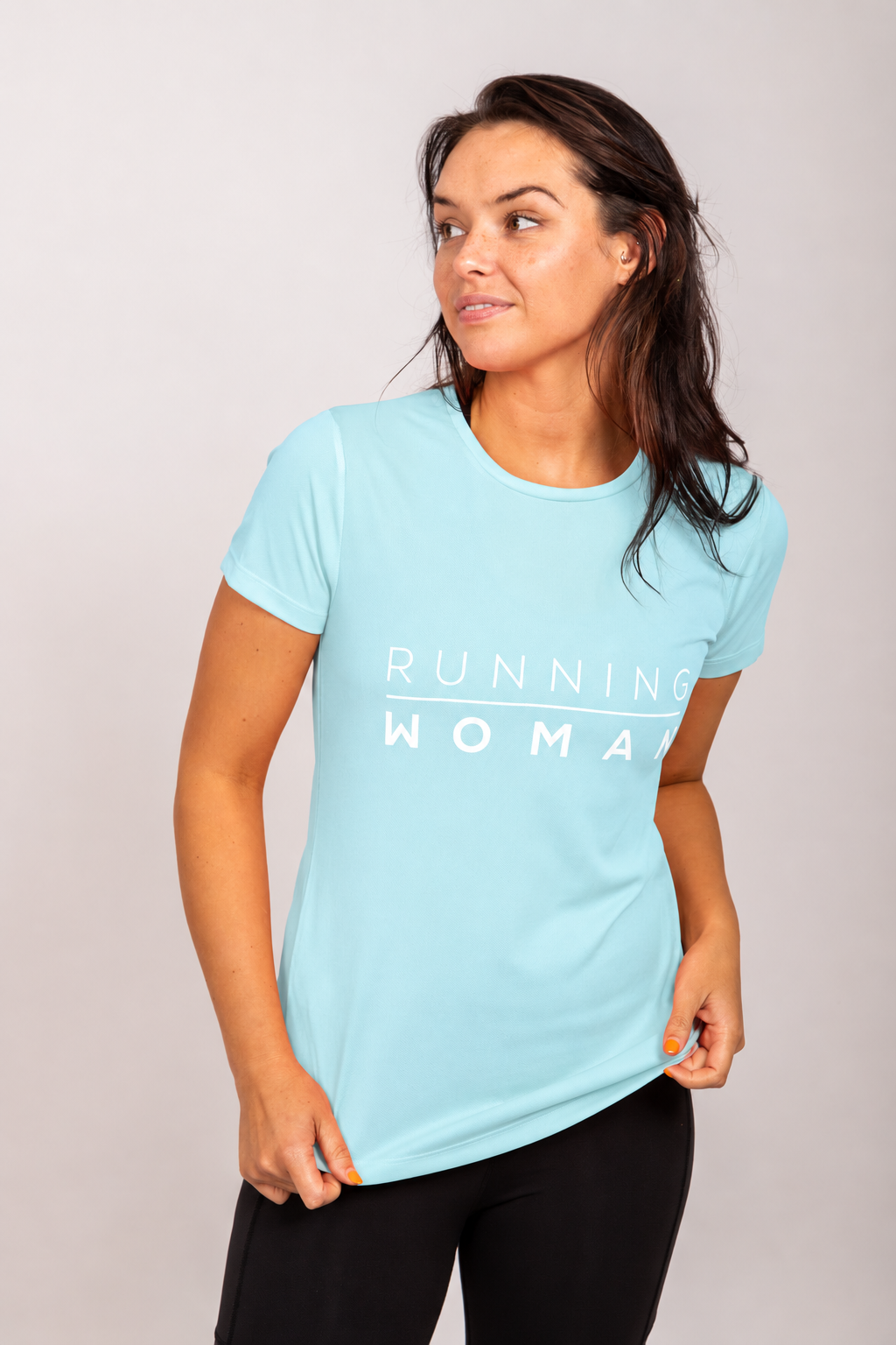 Mint Running Woman running T-shirt on a model looking to the side and holding the hem